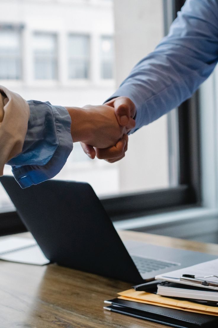 Placeholder: handshake over a laptop